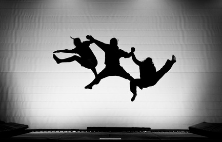 silhouette of friends jumping on trampoline