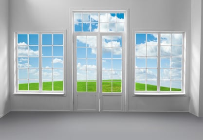 Room with large windows and green grass and blue sky behind includes clipping path