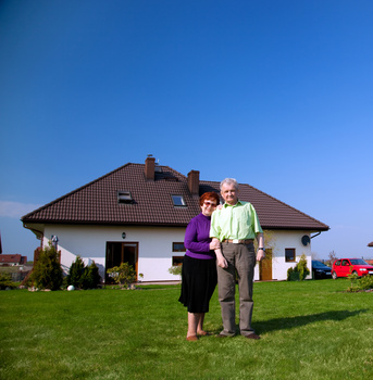 Senior couple in front of the house