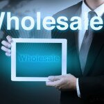 businessman holding tablet showing word WHOLESALE on virtual screen.