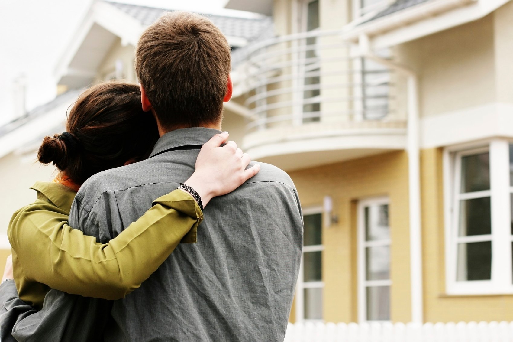 couple in front of onefamily house in modern residential area