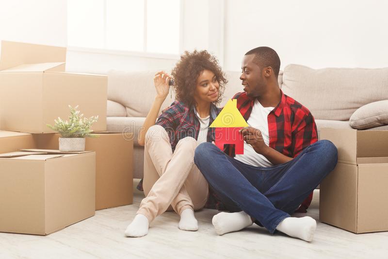 black couple sitting floor new apartment happy african american family house key symbols against near storage boxes 112669596