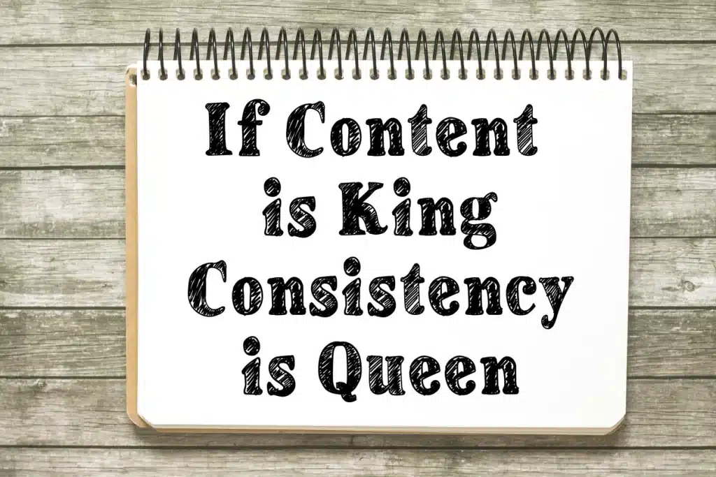 If content is king consistency is queen blogging and social media tip handwriting on a notebook